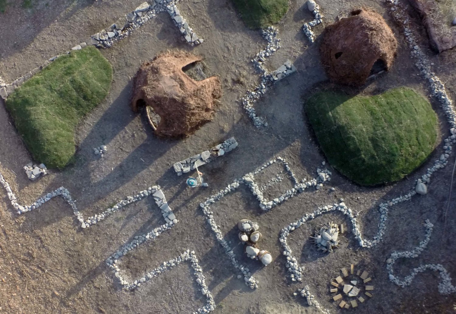 Play landscape with mounds, paths, and woven structures